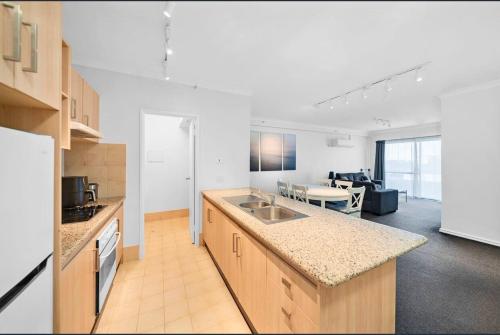 a kitchen with a counter top and a living room at 64 Sweeping Views Eastperth 2br Poolpkg in Perth