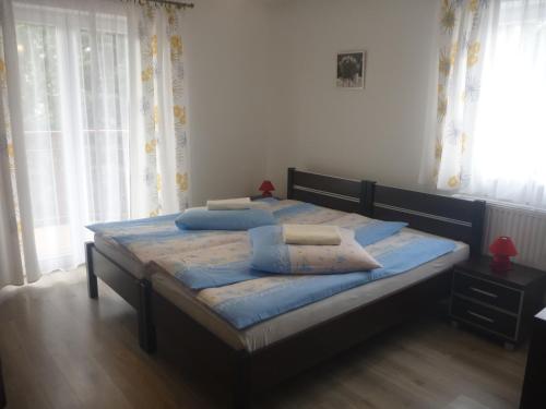 a bedroom with a bed with blue pillows on it at Ośrodek Wypoczynkowy Nad Stawem vis a vis Parku Zdrojowego z Tężnią Solankową - B&B Holiday Resort By The Lake - Erholungsheim Am See - Prázdninový dům U Jezera in Kudowa-Zdrój