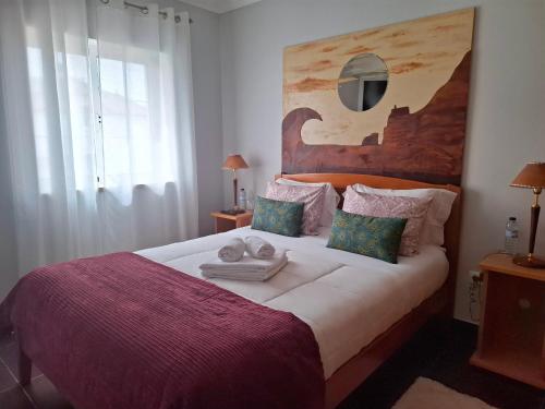a bedroom with a large bed with towels on it at Guesthouse Veríssimo in Nazaré