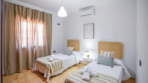 a white room with two beds and a couch at Villa Paqui Villanueva de la Concepción by Ruralidays in Villanueva de la Concepción