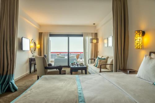 a hotel room with a bed and a living room at Arkin Palm Beach Hotel in Mağusa