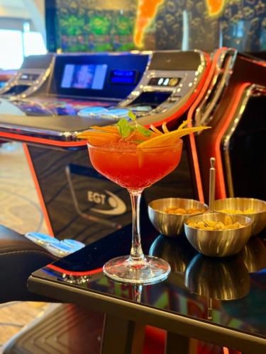 a drink in a martini glass next to a machine at Arkin Palm Beach Hotel in Mağusa