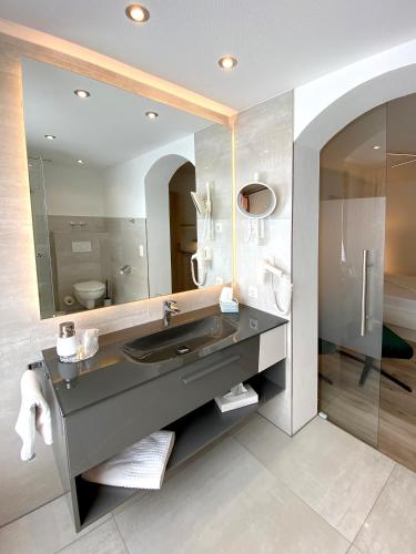a bathroom with a sink and a mirror at Hotel-Restaurant-Kolb in Illertissen