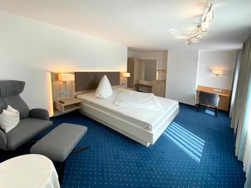 a hotel room with a bed and a chair at Hotel-Restaurant-Kolb in Illertissen