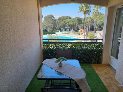 d'une table et de chaises sur un balcon avec vue sur la piscine. dans l'établissement Bel appartement climatisé Saint-Raphaël, à Saint-Raphaël