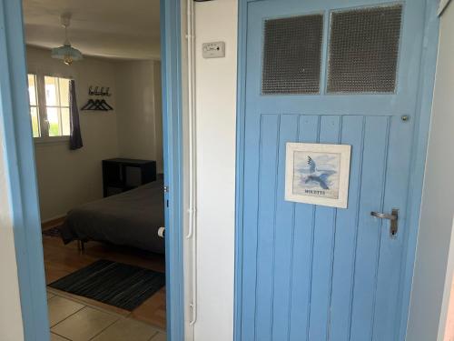 a blue door leading to a bedroom with a bed at Penn Ar Bed & Breakfast in Plozévet