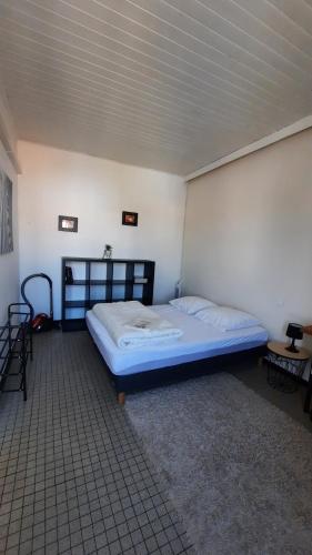 une chambre avec un grand lit dans une pièce dans l'établissement Logement de vacances 4 pers proche plan d'eau, à L'Aiguillon-la-Presqu'île