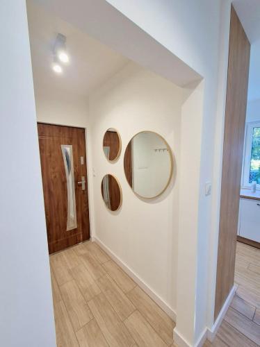 a hallway with a round mirror on a wall at Przystanek Osłonin- całoroczny dom na wynajem in Osłonin