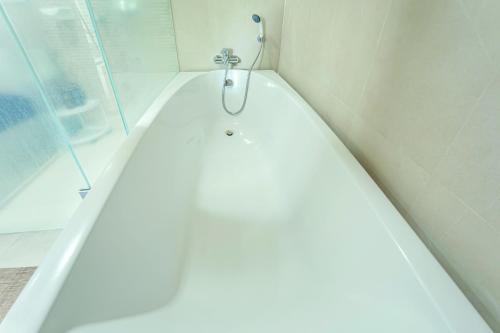 a bath tub with a faucet in a bathroom at A New Experience of Private Vacation and Work in Patong in Patong Beach