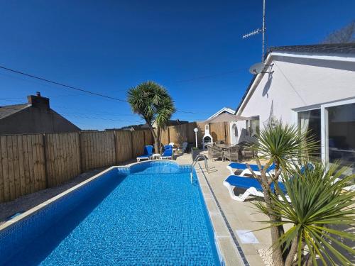 a swimming pool in the backyard of a house at Family Bungalow with Private Pool in Kilgetty