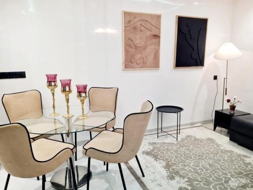 a dining room with a glass table and chairs at Lusail in Beni Mellal