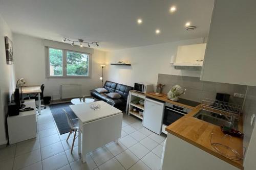 une cuisine et un salon avec un canapé et une table dans l'établissement Appartement Lyon 8 proche métro, à Lyon