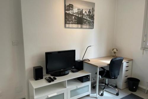 un bureau avec un moniteur et une chaise dans l'établissement Appartement Lyon 8 proche métro, à Lyon