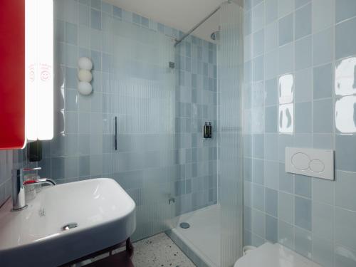 a bathroom with a shower and a toilet and a sink at Conscious Hotel Oudegracht in Utrecht