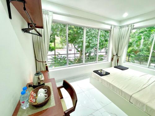 a bedroom with a bed and a table and window at SKY VILLA - BKK Phnom Penh - Rooms & Apartments - FREE LAUNDRY in Phnom Penh