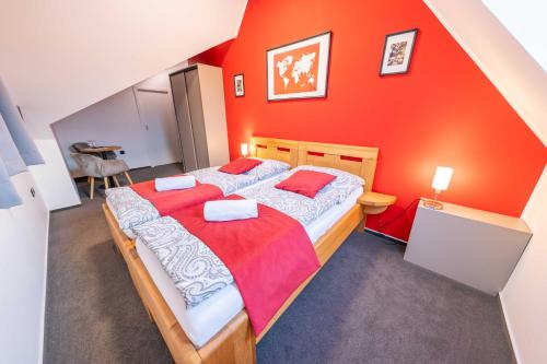 a bedroom with a large bed with an orange wall at Penzion Nad Lávkou in Uherský Brod