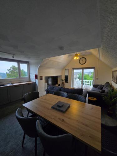 a living room with a wooden table and chairs at Beautiful apartment with private pool near Tenby in Kilgetty