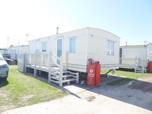 a white trailer with a red fire hydrant next to it at Beachside, Family-friendly, WiFi, 6 berth caravans in Ingoldmells