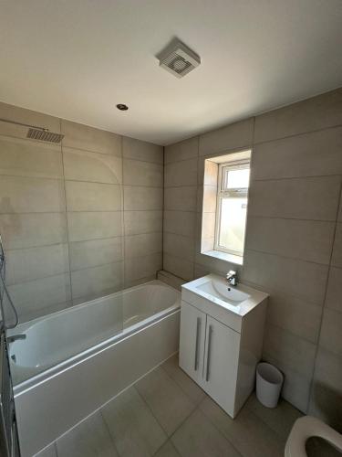 a bathroom with a tub and a sink and a toilet at Charming and Cosy 4 bedroom House - Stockport in Bredbury