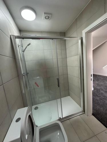 a shower stall in a bathroom with a toilet at Charming and Cosy 4 bedroom House - Stockport in Bredbury