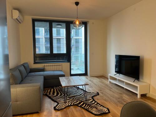a living room with a couch and a television at BW Eterna Apartment in Sajmište