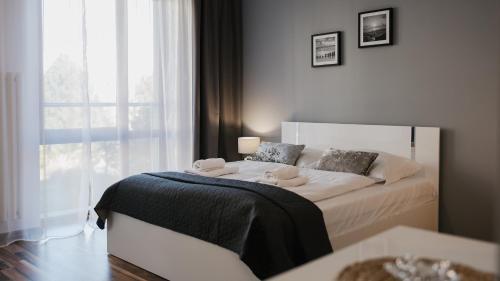 a bedroom with a bed with a large window at Wczasowa, Sun & Snow in Ustka