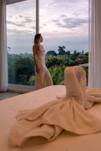 a woman in a wedding dress standing in front of a window at Place of Power in Blahbatu