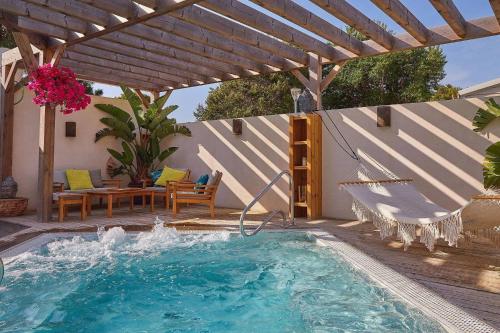 - une piscine avec une pergola, une table et des chaises dans l'établissement Narbonne Plage, à Narbonne-Plage