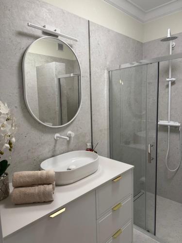 a white bathroom with a sink and a mirror at Apartament BULVAR MOOD Stare Miasto - Elbląg Centrum in Elblag