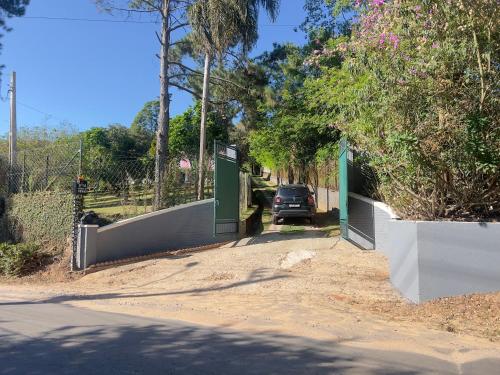 a car parked in a driveway with a gate at Chalé Encantador na Rota do Vinho com Ar Condicionado in São Roque