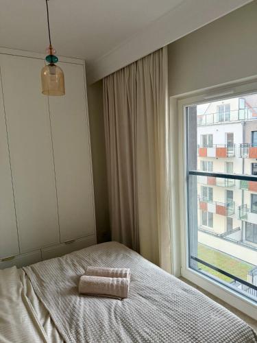 a bedroom with a bed and a large window at Apartament BULVAR MOOD Stare Miasto - Elbląg Centrum in Elblag