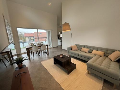 ein Wohnzimmer mit Sofa und Tisch in der Unterkunft Le spacieux au dernier étage avec vue dégagée in Arthaz-Pont-Notre-Dame