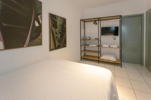 a bedroom with a white bed and a mirror at Apartamento Economico - AL18 in Maringá