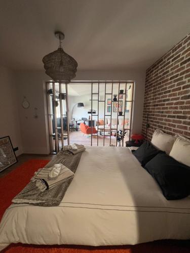 un grand lit dans une pièce avec un mur de briques dans l'établissement Champagne et Jacuzzi, à Merrey-sur-Arce