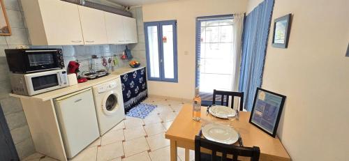 a small kitchen with a table and a microwave at Carpe Diem in Sérignan