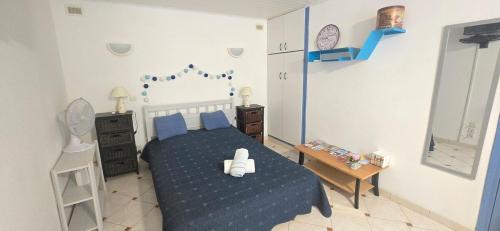 a bedroom with a bed with a blue bedspread at Carpe Diem in Sérignan