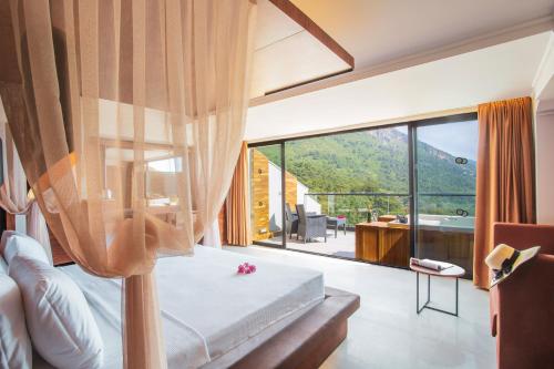 a bedroom with a bed and a large window at Orka Sunlife Resort Hotel and Aquapark in Oludeniz