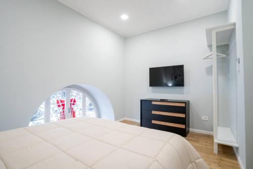 una camera da letto bianca con un letto e una TV di Blue Dream Suites a Salerno