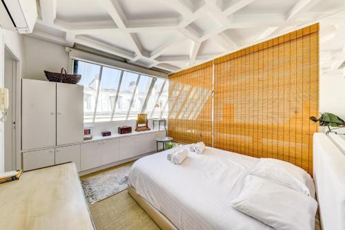une chambre avec un lit blanc et un mur jaune dans l'établissement Le Montparnasse - Wifi - Climatisation, à Paris