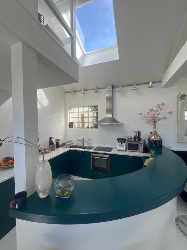 - une cuisine avec un comptoir bleu dans une pièce dans l'établissement Large unique loft, quiet and bright & outdoor, à Bagnolet