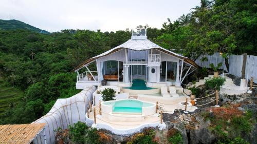 a house with a gazebo with a swimming pool at Honeymoon Villa Sea View - Nusa Penida in Nusa Penida