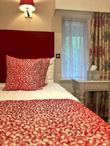 a bedroom with a bed with a red headboard and a window at The Casa Hotel, Sure Hotel Collection by Best Western in Yateley