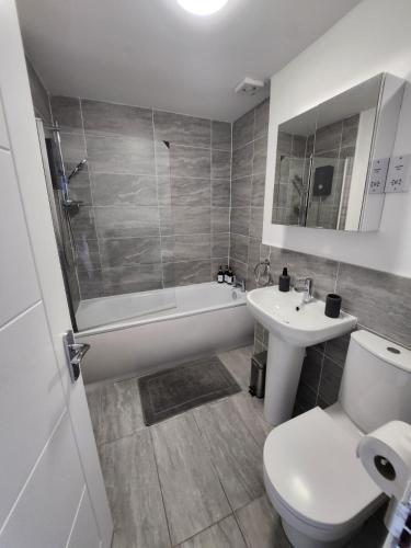 a bathroom with a toilet and a tub and a sink at Bright City Apt - King Bed - Parking & Wi-Fi in Dundee