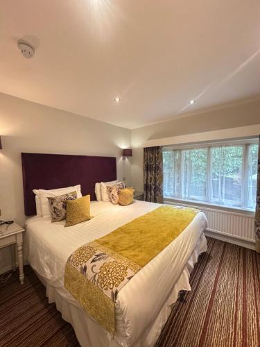 a bedroom with a large bed with a large window at The Casa Hotel, Sure Hotel Collection by Best Western in Yateley