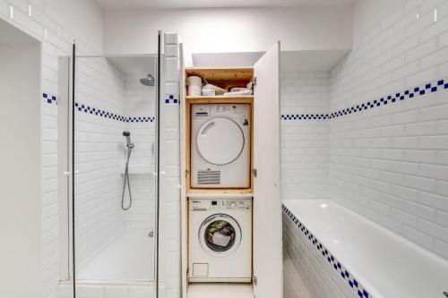 une salle de bain avec un lave-linge et une baignoire dans l'établissement Le Montparnasse - Wifi - Climatisation, à Paris
