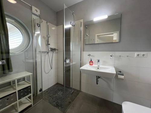 a bathroom with a sink and a shower at Kabine 8 in Grömitz