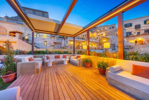 a deck with couches and tables on a building at Taskonaklar in Uchisar