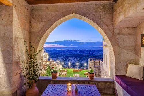 an arched window in a stone building with a table at Taskonaklar in Uchisar