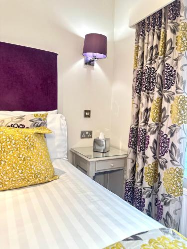 a bedroom with a bed and a table with a lamp at The Casa Hotel, Sure Hotel Collection by Best Western in Yateley
