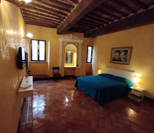 a bedroom with a blue bed in a room at My home apartments in Pienza
